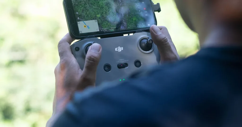Do I Need an SFOC? 3 Clear Questions for Canadian Pilots 1 Drone pilot checking the controller screen mid-flight while deciding do I need an SFOC for this operation