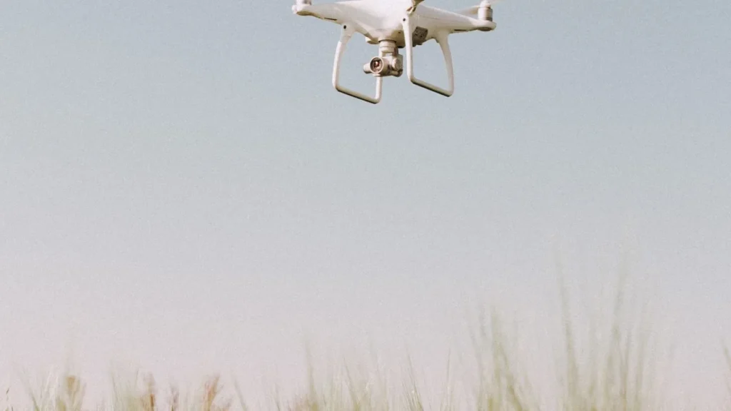 Drone Flying Guide for Canada: 3 Certificates Made Clear 4 Drone hovering over a wheat field, one of the trades covered in this drone flying guide